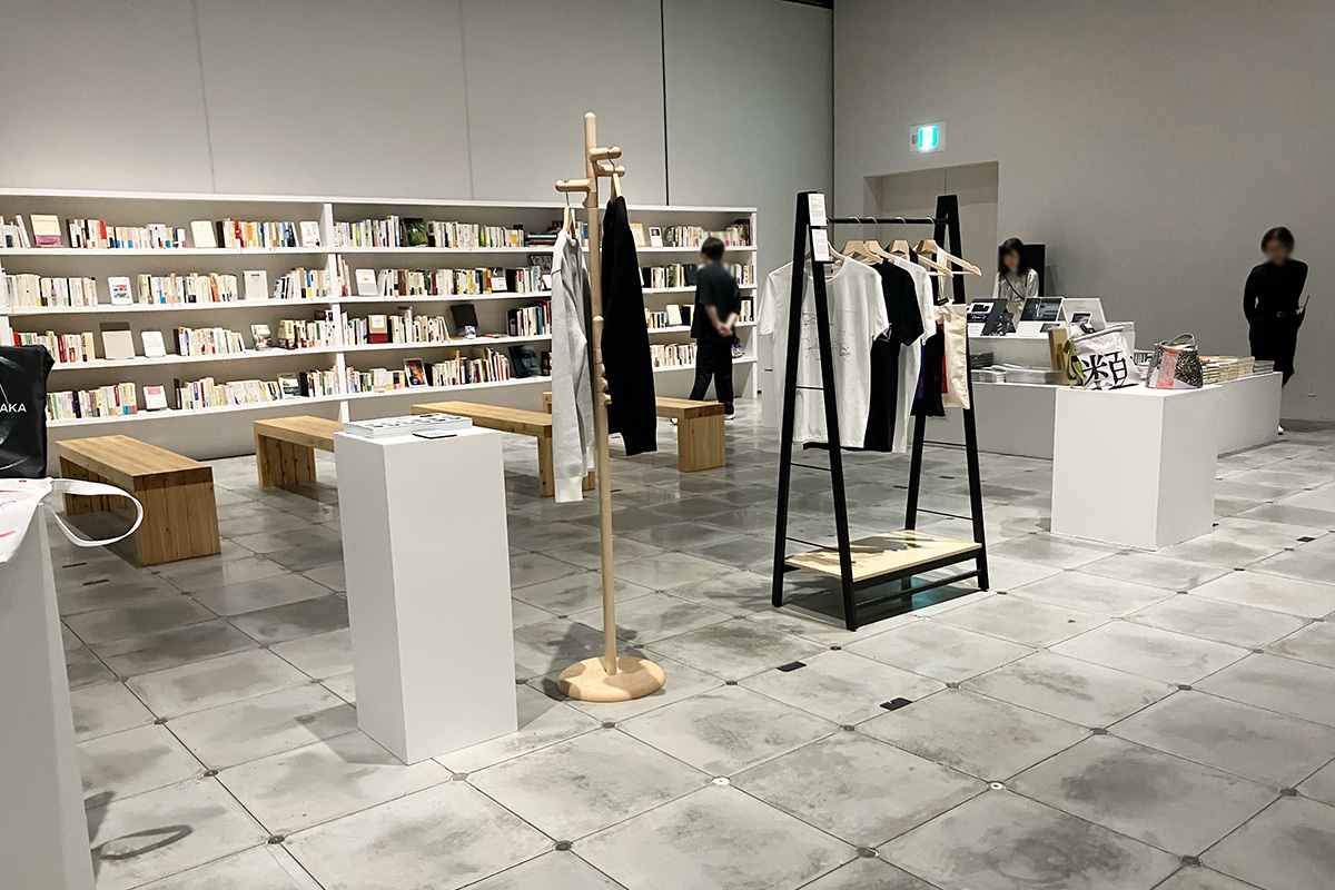 オリジナルグッズの奥に見えるのは、再現された読書空間「坂本図書」（2025年8月、大阪・VS.） 