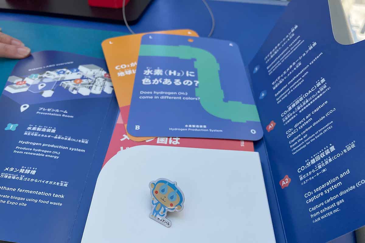 見学ツアーの参加者には最新技術を紹介した冊子と、e-メタンくんのピンバッチがプレゼント（2025年・化けるLABO）