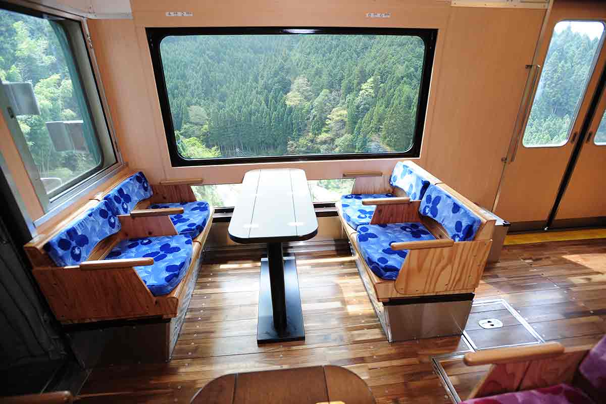 着席したまま谷間が見下ろせる腰窓も設置されている、観光列車「天空」の4人掛けコンパートメント座席（提供画像）