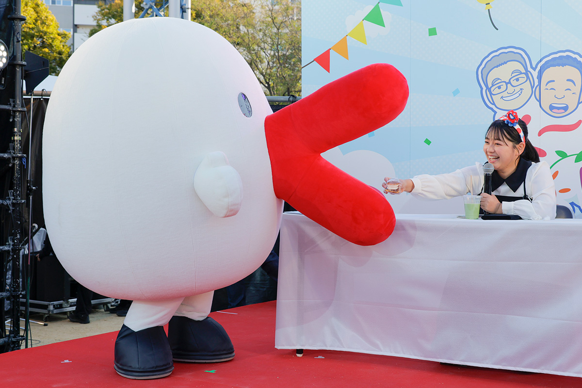 ハチエモンに生どら焼きをプレゼントするカンテレの谷元星奈アナウンサー（2025年11月23日・大阪市北区）