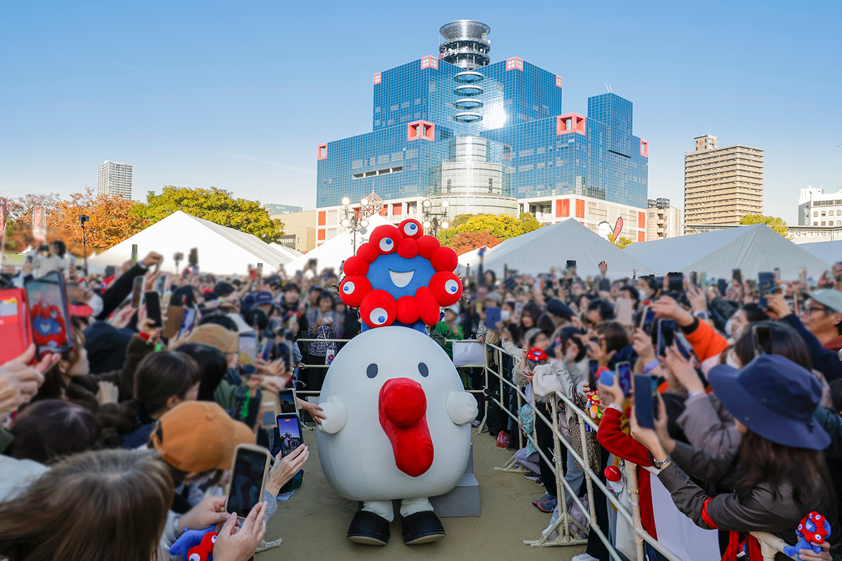 客席からの撮影に応じるミャクミャクとハチエモン（2025年11月23日・大阪市北区）