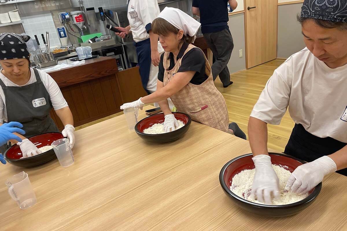 今回の取材会には、ファンコミュニティ・丸亀製麺Mochi-Mochiクラブの会員さんが参加。手に絡みつく粉を急いで混ぜます