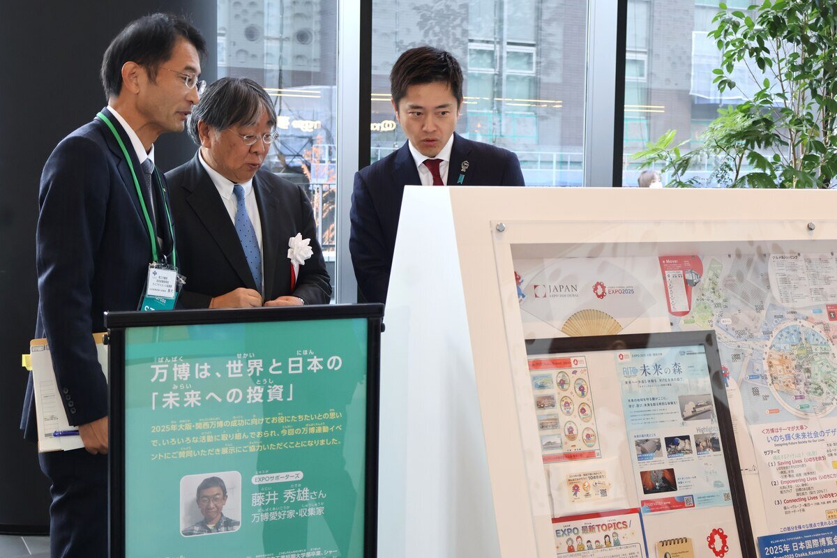 「万博おじさん」こと藤井秀雄さんの展示を見る吉村知事ら（12月12日、中之島クロス）