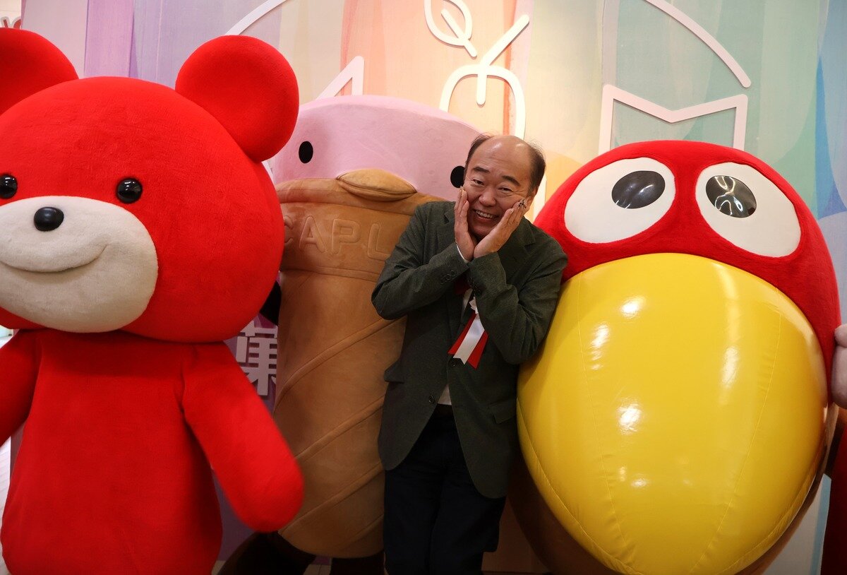 お菓子のキャラクターたちとポーズをとる吉寿屋の神吉一寿社長（12月19日、お菓子ミュージアム）