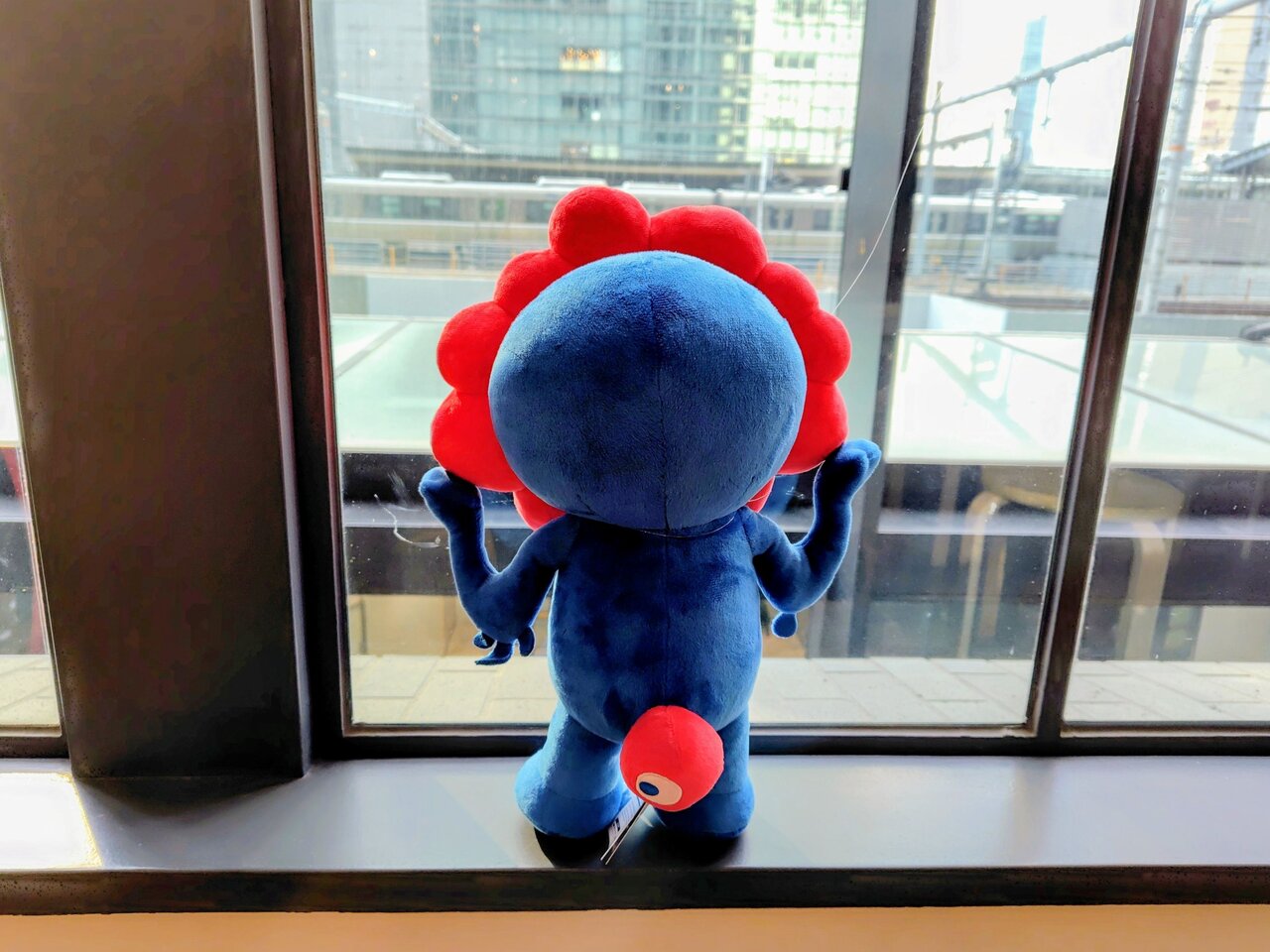 窓の外を見つめるミャクミャクも（２月16日、大阪市北区）