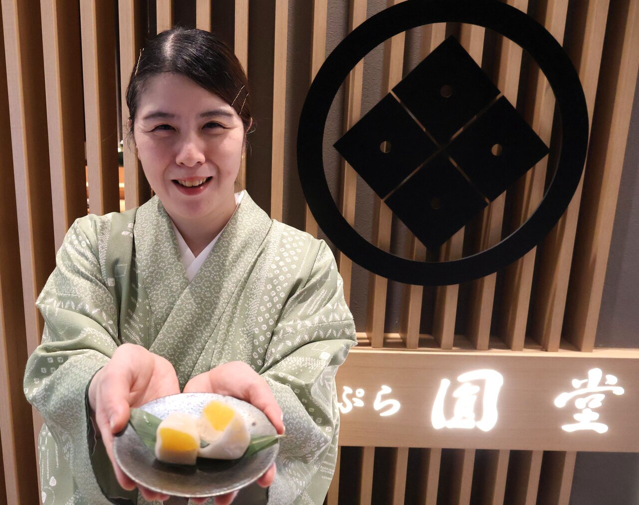 「はっさく大福」を笑顔で持つ野室圭奈子さん（大阪市北区、２月16日）