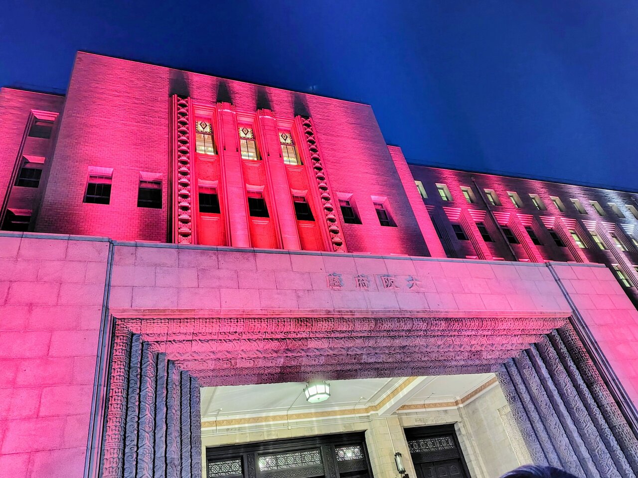 １時間に１回、点灯される「季節の色」。２月は、梅の花をイメージした赤（大阪市中央区、２月19日）