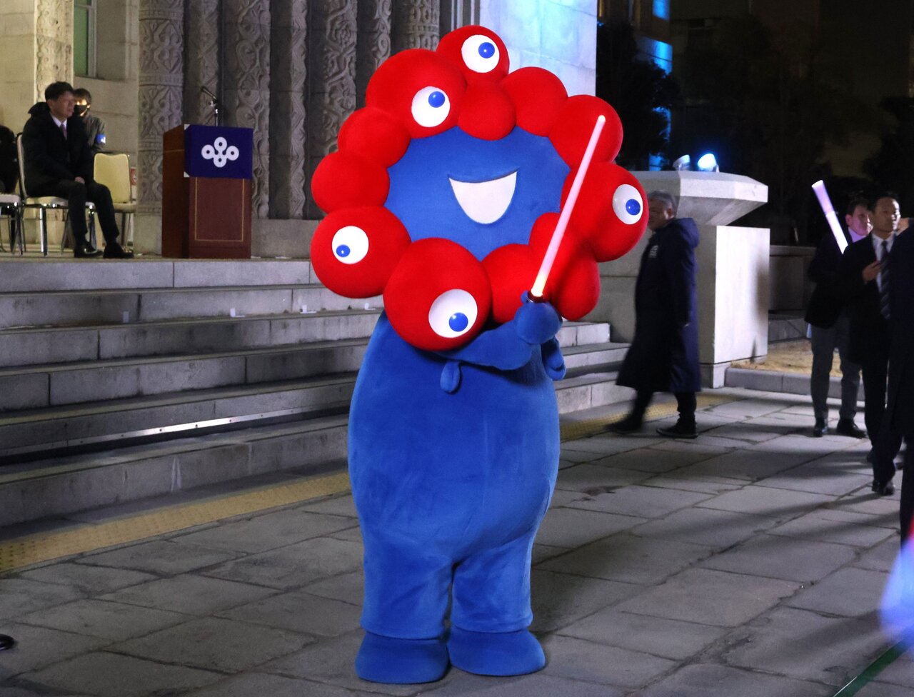 号令棒を持つミャクミャク（大阪市中央区、２月19日）