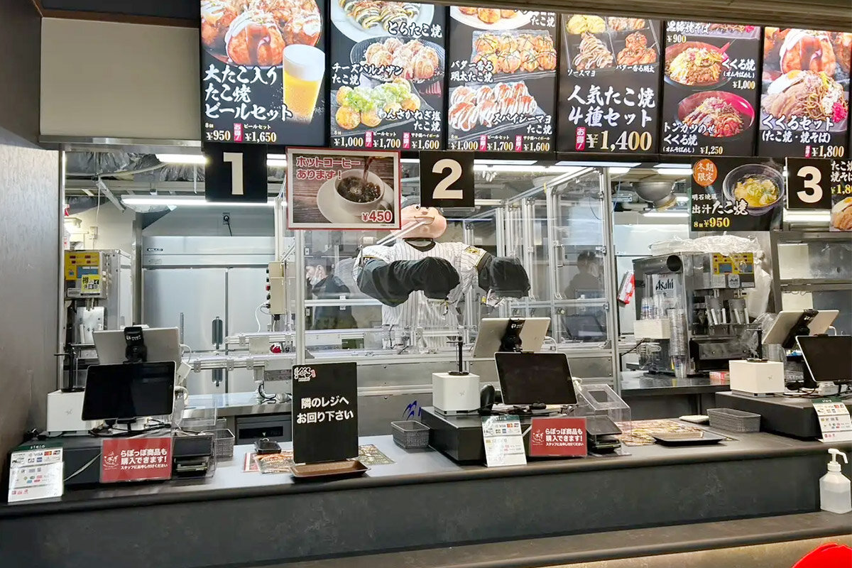 「たこ家道頓堀くくる 阪神甲子園球場店」（兵庫県西宮市）に登場した、たこ焼きお助けトッピングロボット「くくる君」