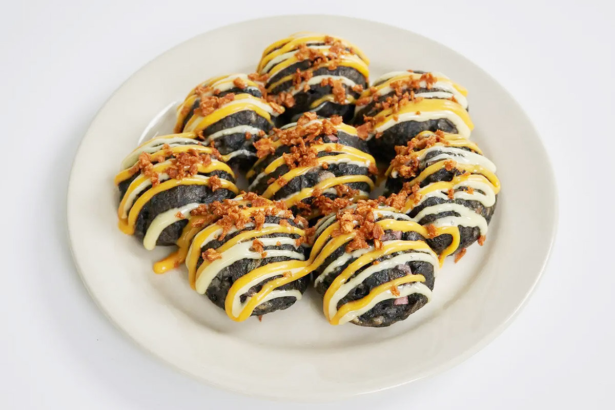 黒色の生地と黄色のソースで虎柄になった、阪神甲子園球場限定メニュー「とらたこ焼」（950円・税込）