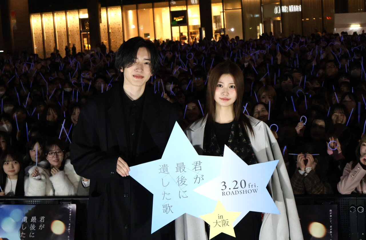 3500本の青のサイリウムとファンを背景にフォトセッションを行う道枝駿佑さんと生見愛瑠さん（３月11日、大阪市北区）