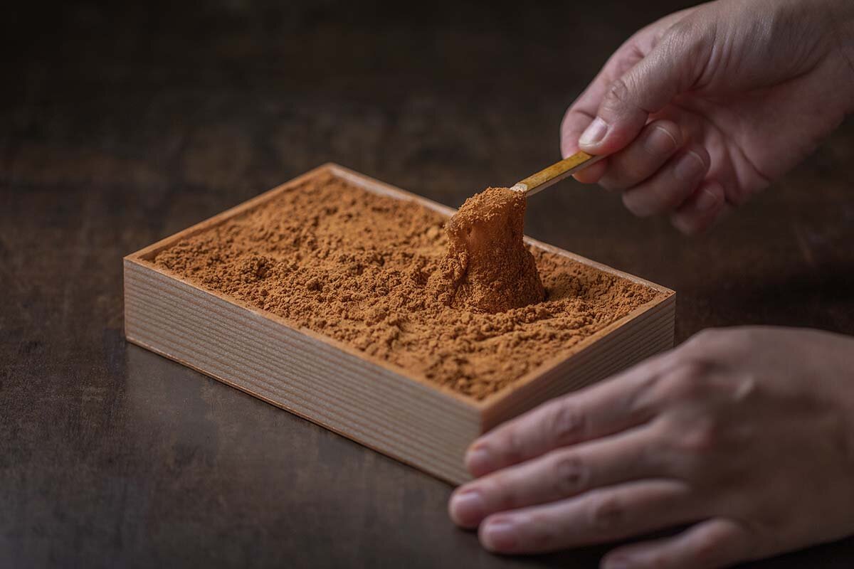 あふれそうなほど箱いっぱいに敷き詰めたきな粉から、そっとわらび餅を取り出す「ツバメわらび」（10切入1,358円）