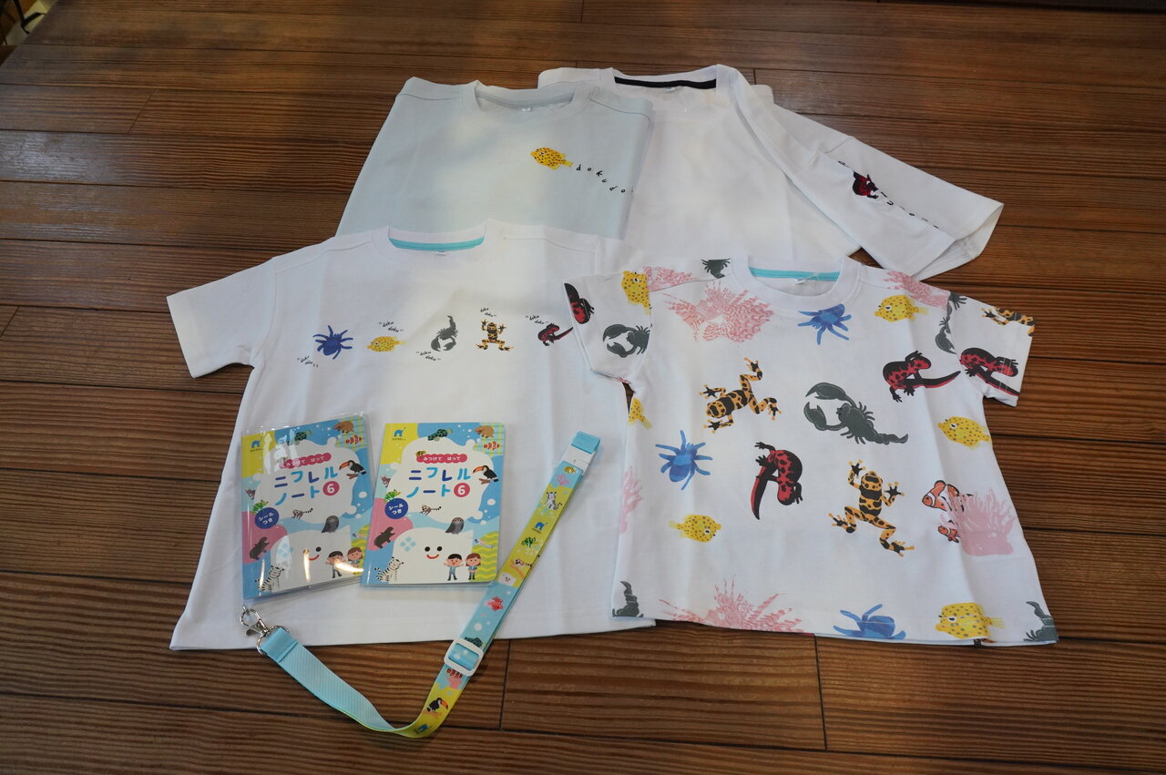 「DOKUDOKU Tシャツ」（子ども用3,000円、大人用3,500円）、「ニフレルノート」（300円）