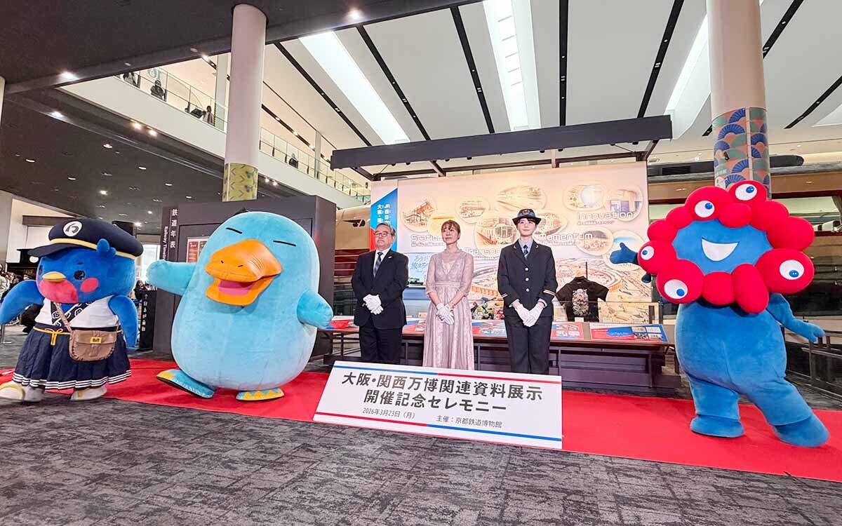 左から「大阪・関西万博関連資料展示」初日に開催された開催記念セレモニーに参加したウメテツ、カモノハシのイコちゃん、京都鉄道博物館の松岡館長、河野真弓さん、瀧野由美子さん、ミャクミャク（撮影2026年3月23日）
