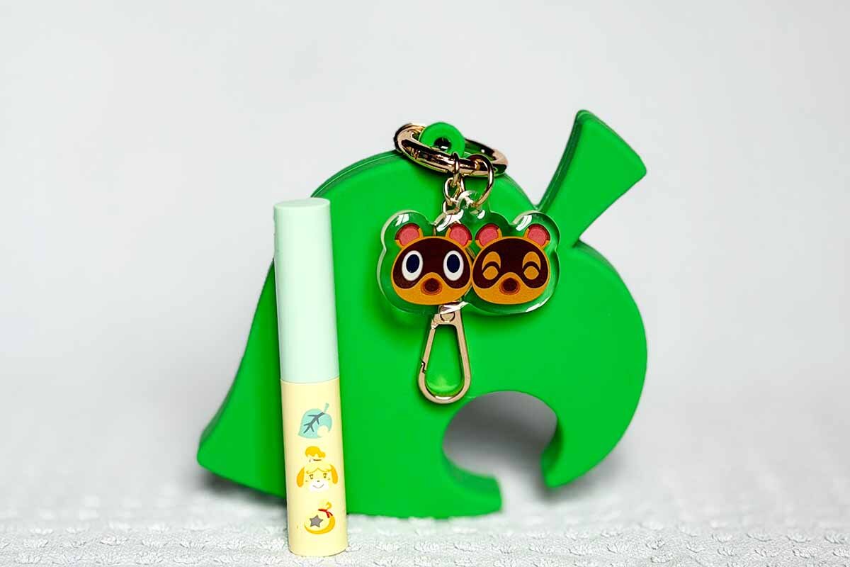 「＜どうぶつの森＞ミティア　セラムオイルリップスティック」（全6色・各995円）とファミマオンライン限定で販売される「どうぶつの森」の葉っぱのマーク型の「シリコンリップケース」（2,200円）