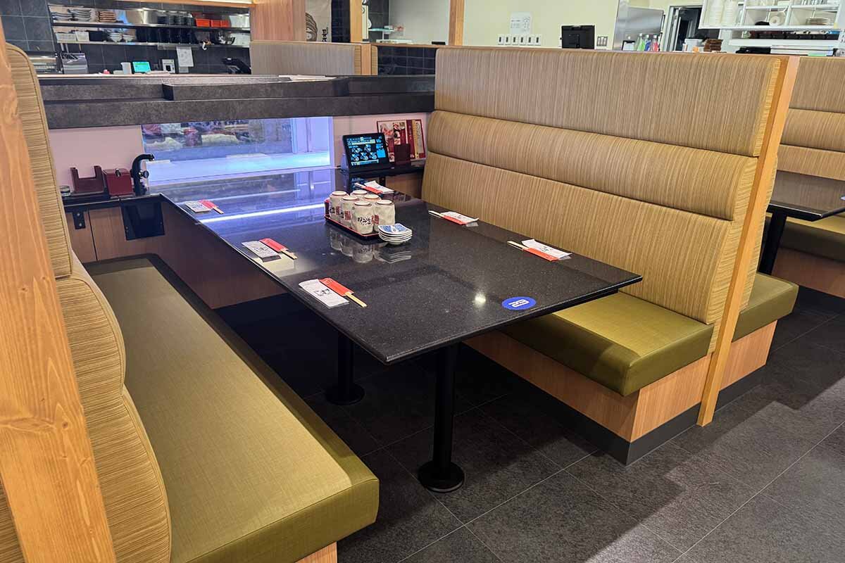 二段のレーンから料理が運ばれる6名掛けのテーブル席