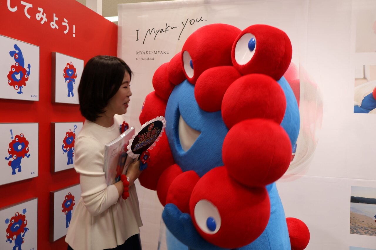 ミャクミャクとハグをするファン（４月13日、大阪市北区）