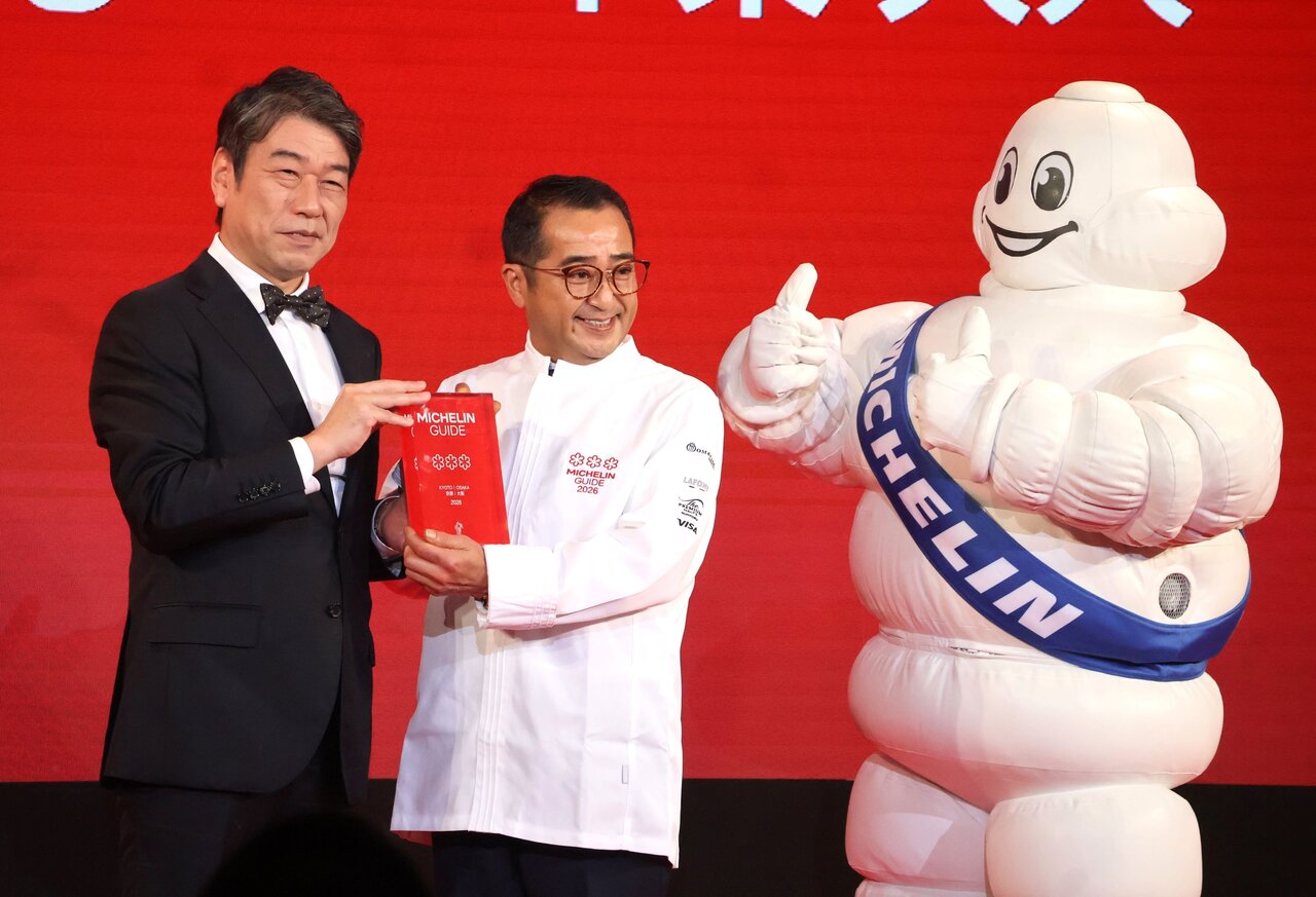 日本ミシュランタイヤ株式会社の須藤元社長（左）から盾を受け取る「美山荘」の中東久人さん（４月23日、大阪市中央区）