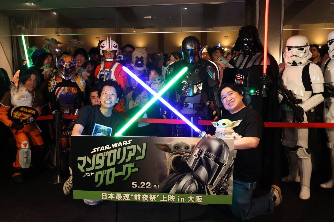 『スター・ウォーズ』のコスプレに身を包んだファンと記念撮影をする「ニッポンの社長」の辻皓平さん（左）とケツさん（５月21日、大阪市北区