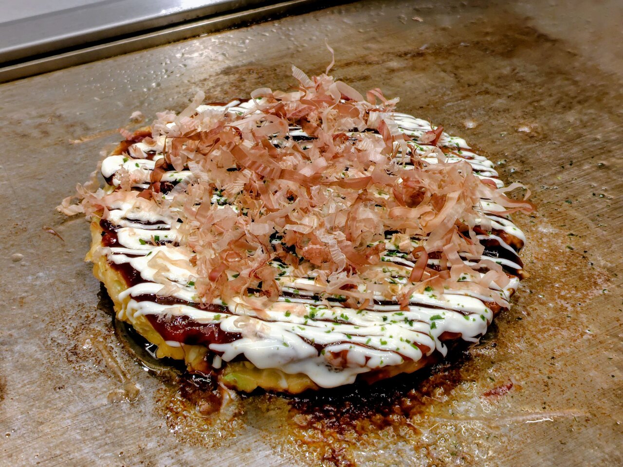 鉄板を使って焼くお好み焼きを味わえる（５月27日、大阪市城東区）