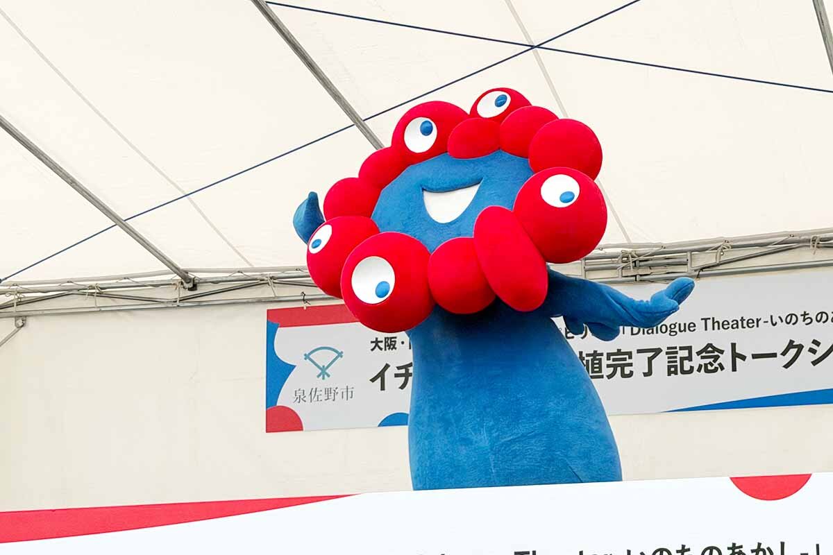 いつものかわいいポーズを決めるミャクミャク（泉佐野丘陵緑地・2026年6月）