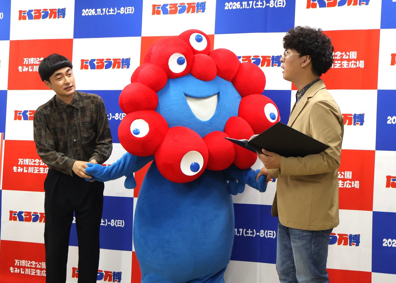 ミャクミャクと手をつなぎ、再会を喜ぶ「たくろう」（７月３日、大阪市中央区）