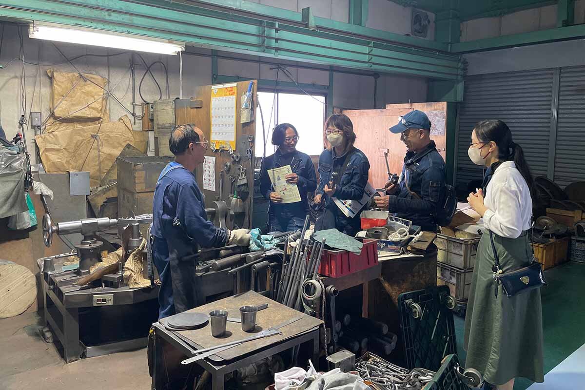 金属板を回転させて、「へら」と呼ばれる棒を押して照明の部品をつくる会社「青戸金属」