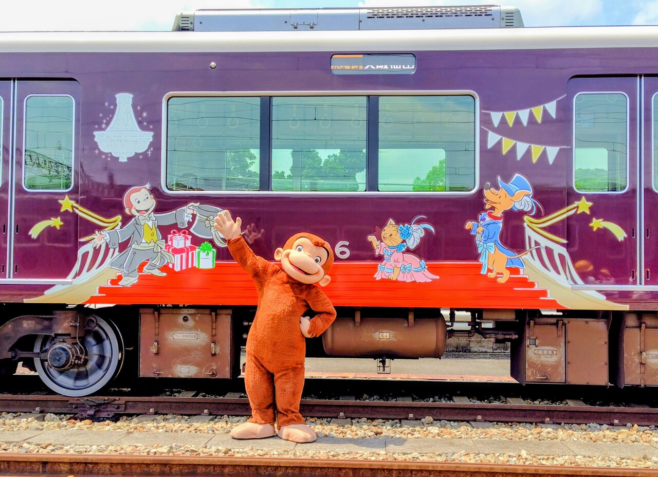 宝塚大劇場デザインの前でポーズをとる「おさるのジョージ」（７月30日、兵庫県宝塚市）　©&®UCS LLC and HC LLC ©Hankyu Corp.