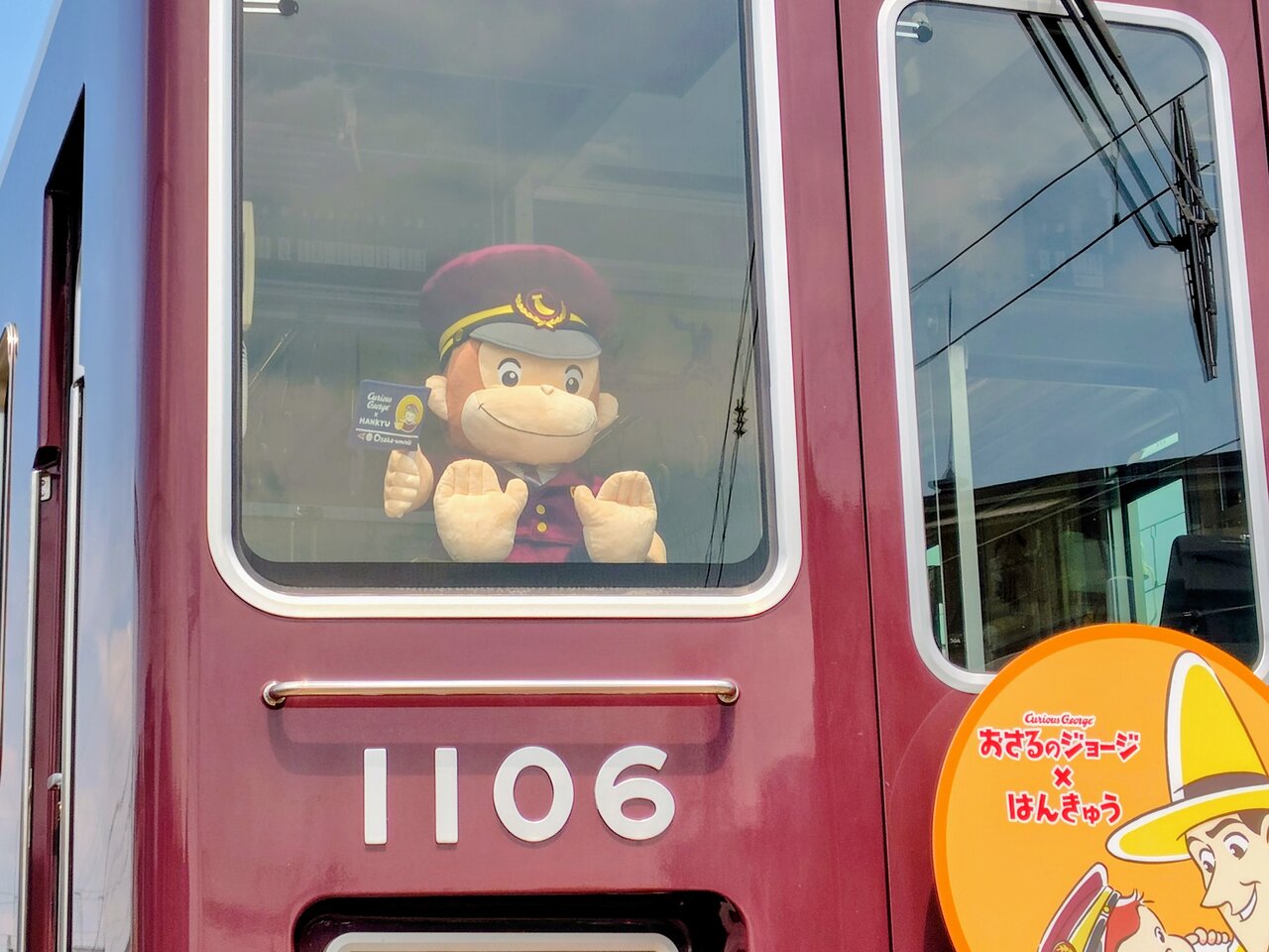 「おさるのジョージ号」の乗務員室に添乗する制服姿の「おさるのジョージ」（７月30日、兵庫県宝塚市）　©&®UCS LLC and HC LLC ©Hankyu Corp.