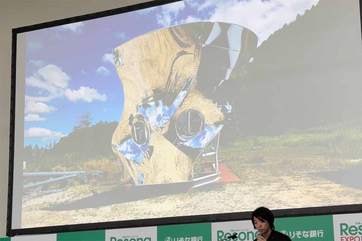 本邦初公開という、建築中の「テトラヌル」の外観を紹介する落合氏（2026年8月・ATCホール）