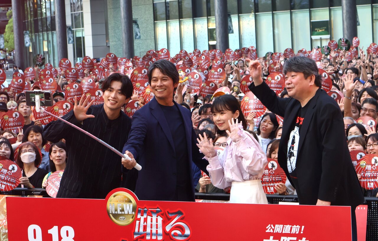 自撮り棒での撮影を楽しむ織田裕二さんら（９月13日、大阪市北区）