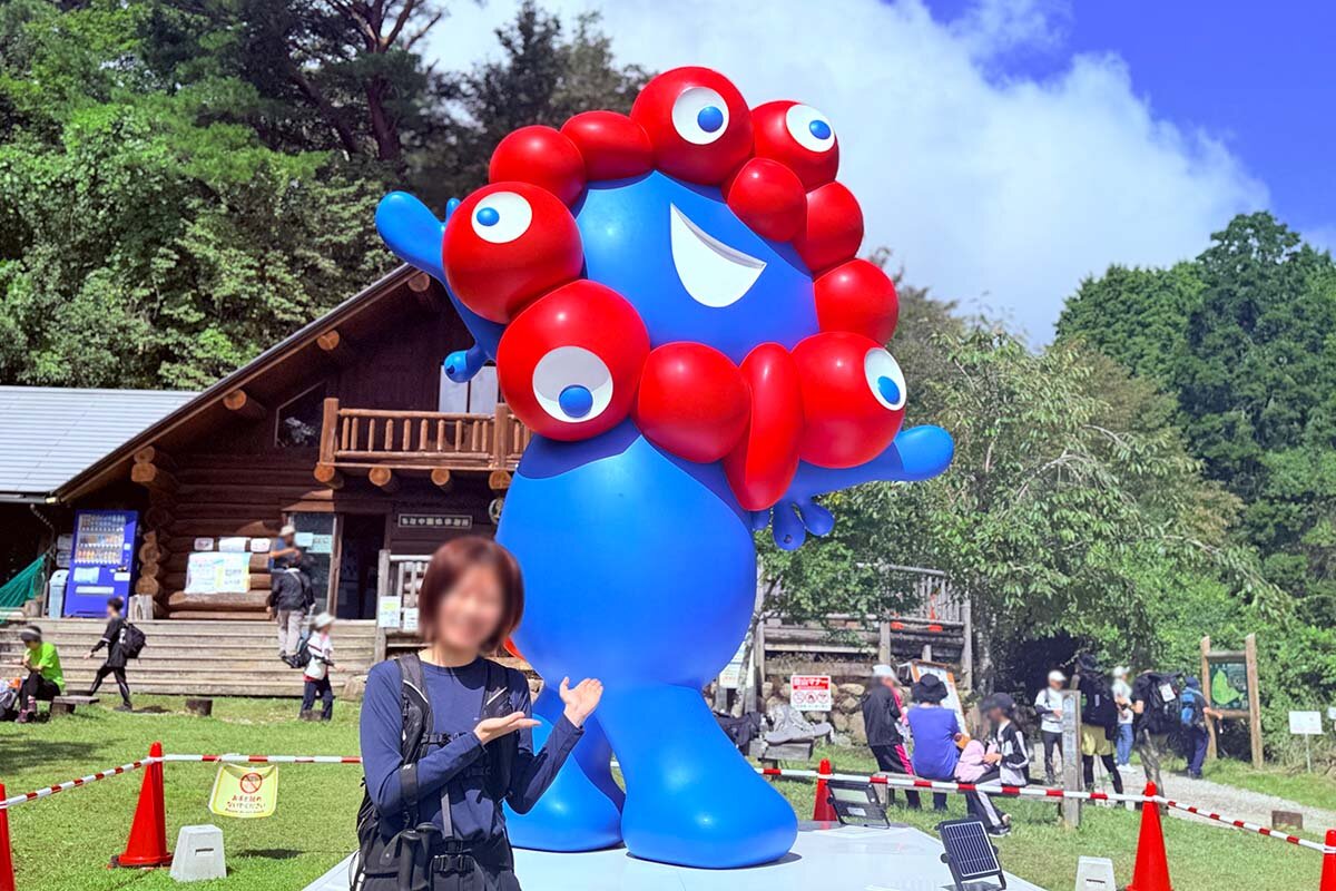 列に並んでミャクミャクと記念撮影し、ごきげんのみよか編集部員（2026年9月、ちはや園地）